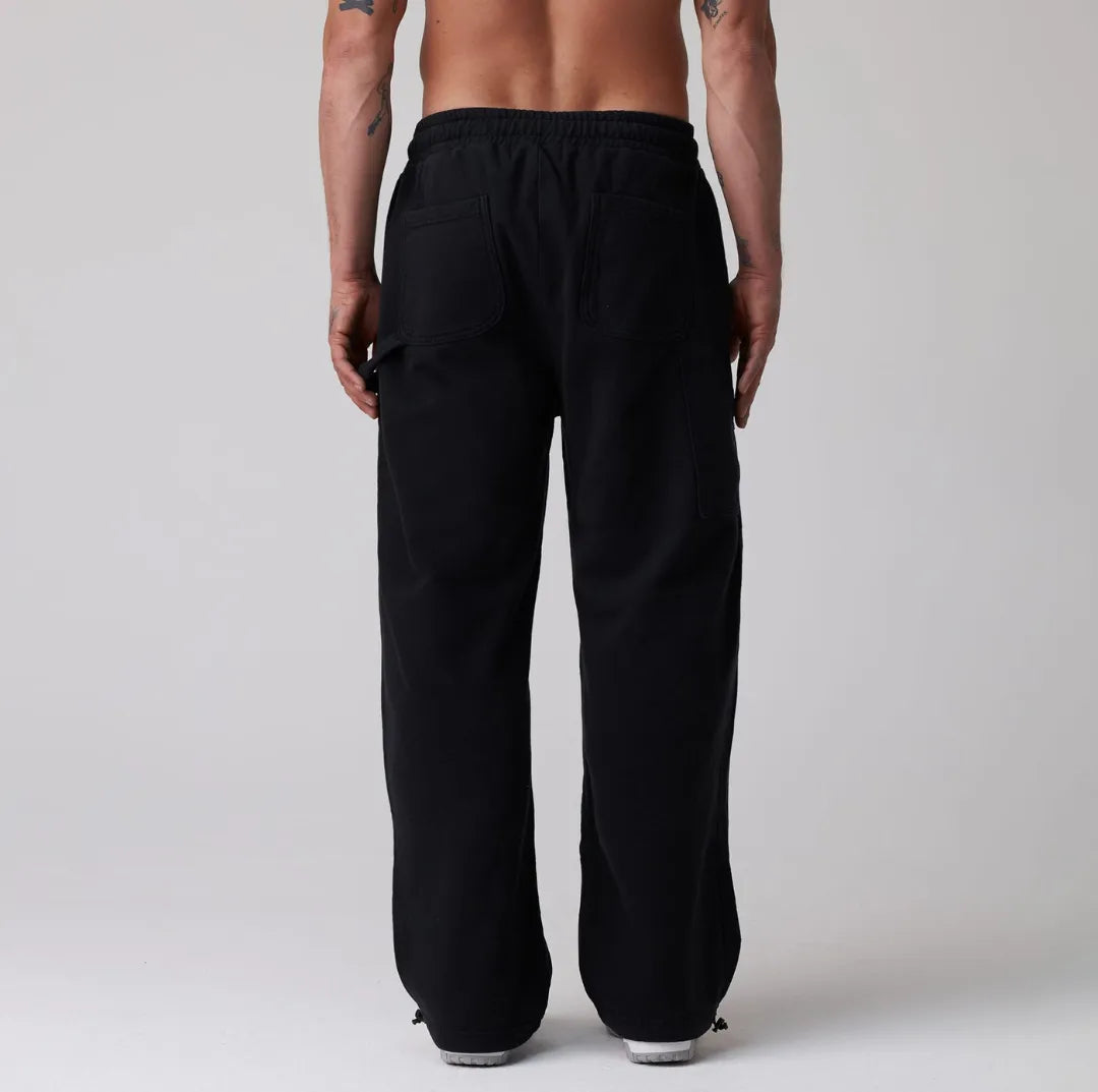 Person wearing black sweatpants on a plain background