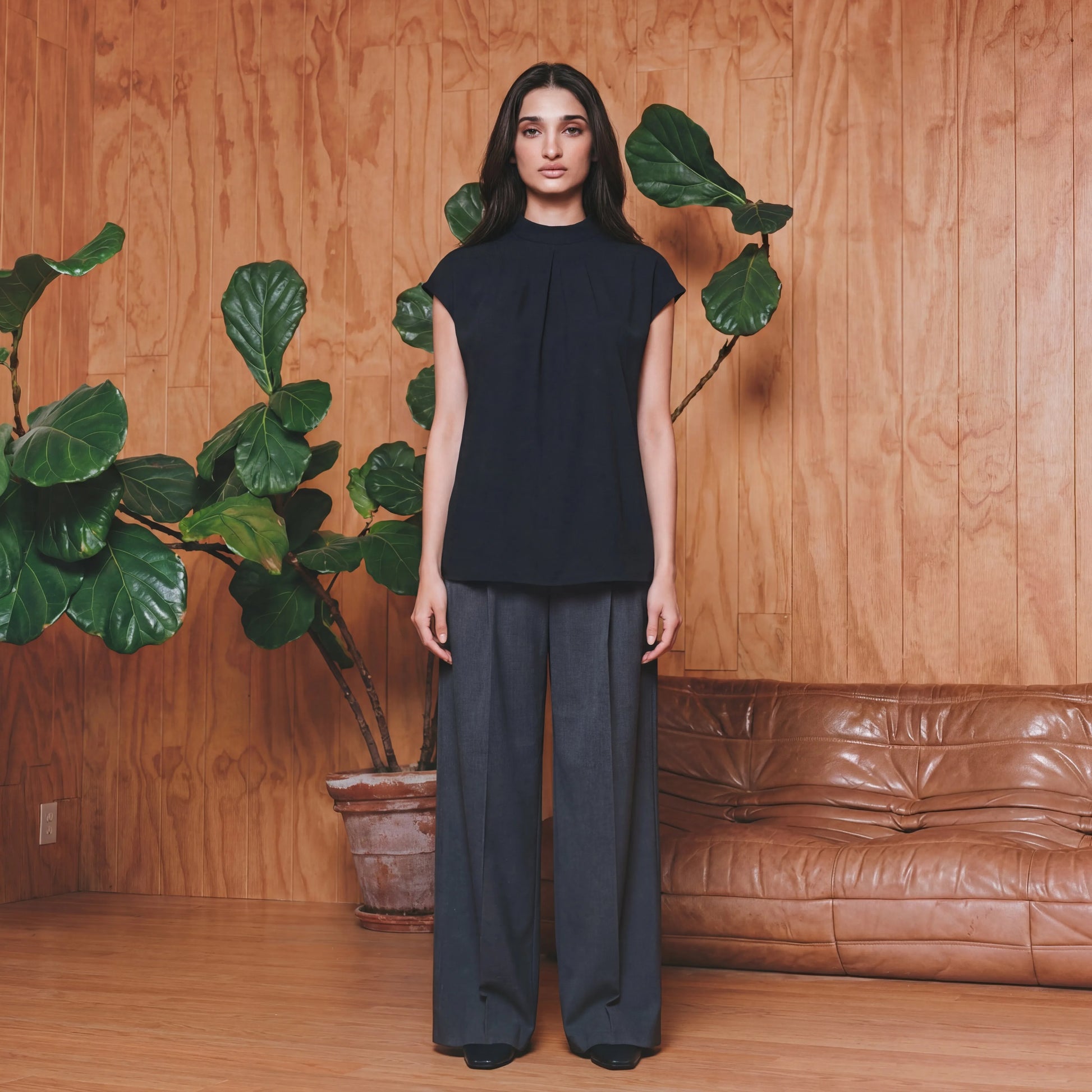 Woman in a black work top and grey pants 