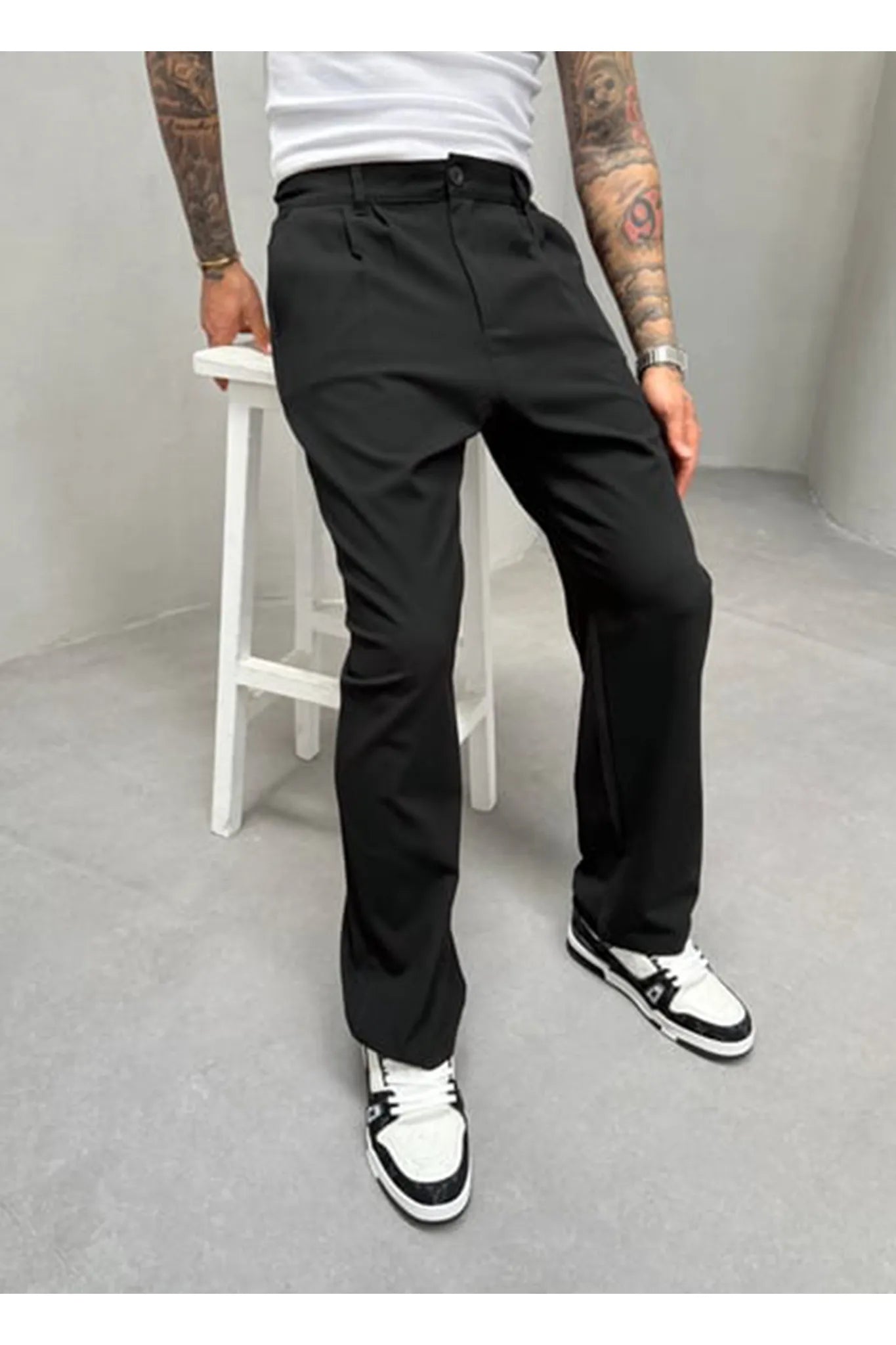 Person wearing black pleated office pants 