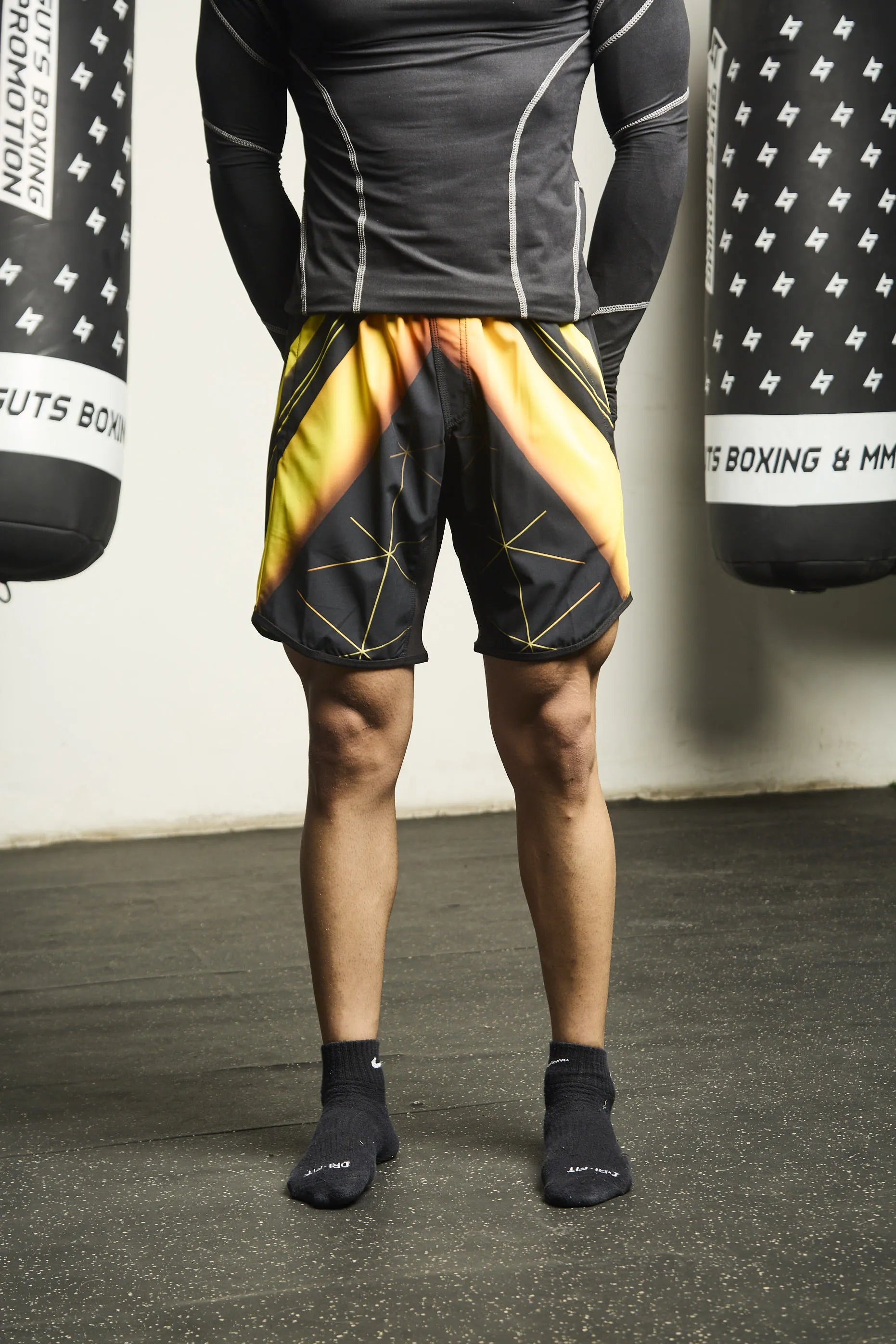Person wearing black Upshift MMA Shorts with Everdion logo