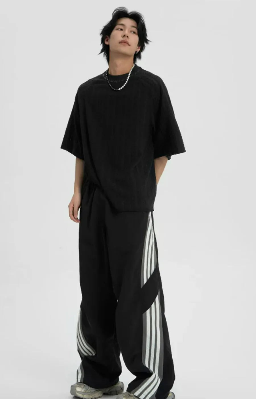Person wearing a black outfit with a white background
