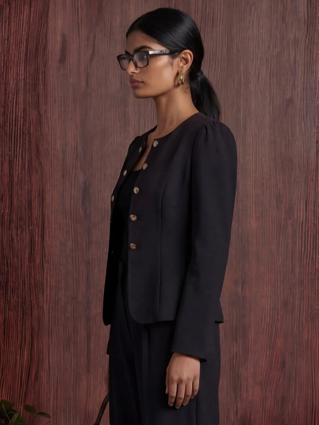 Woman wearing a black blazer against a wooden background