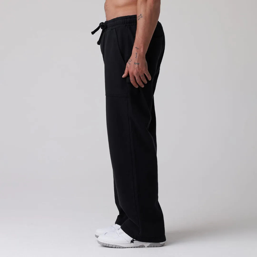 Person wearing black sweatpants on a plain background