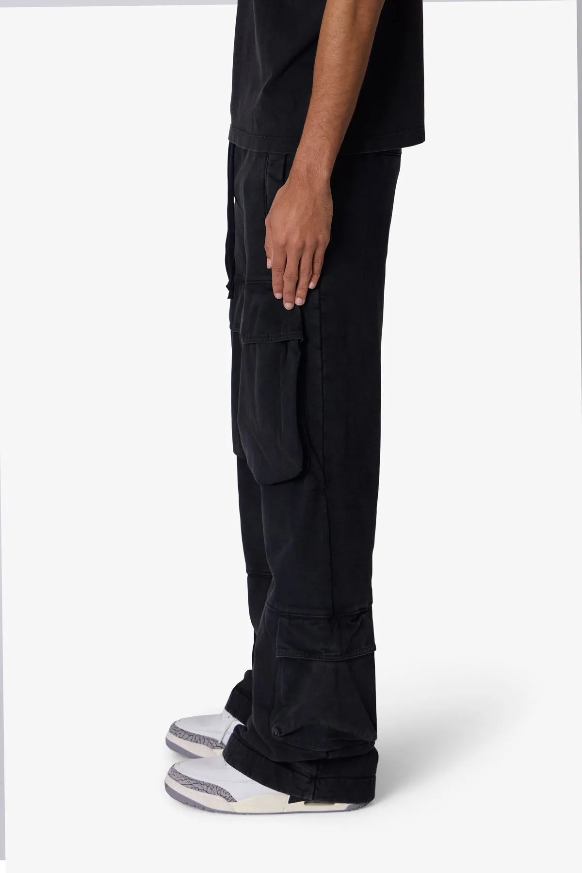 Black cargo pants worn by a person on a white background