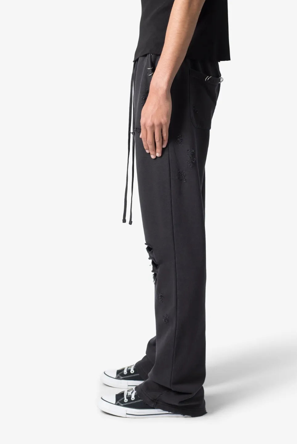 Person wearing black sweatpants with drawstrings on a white background