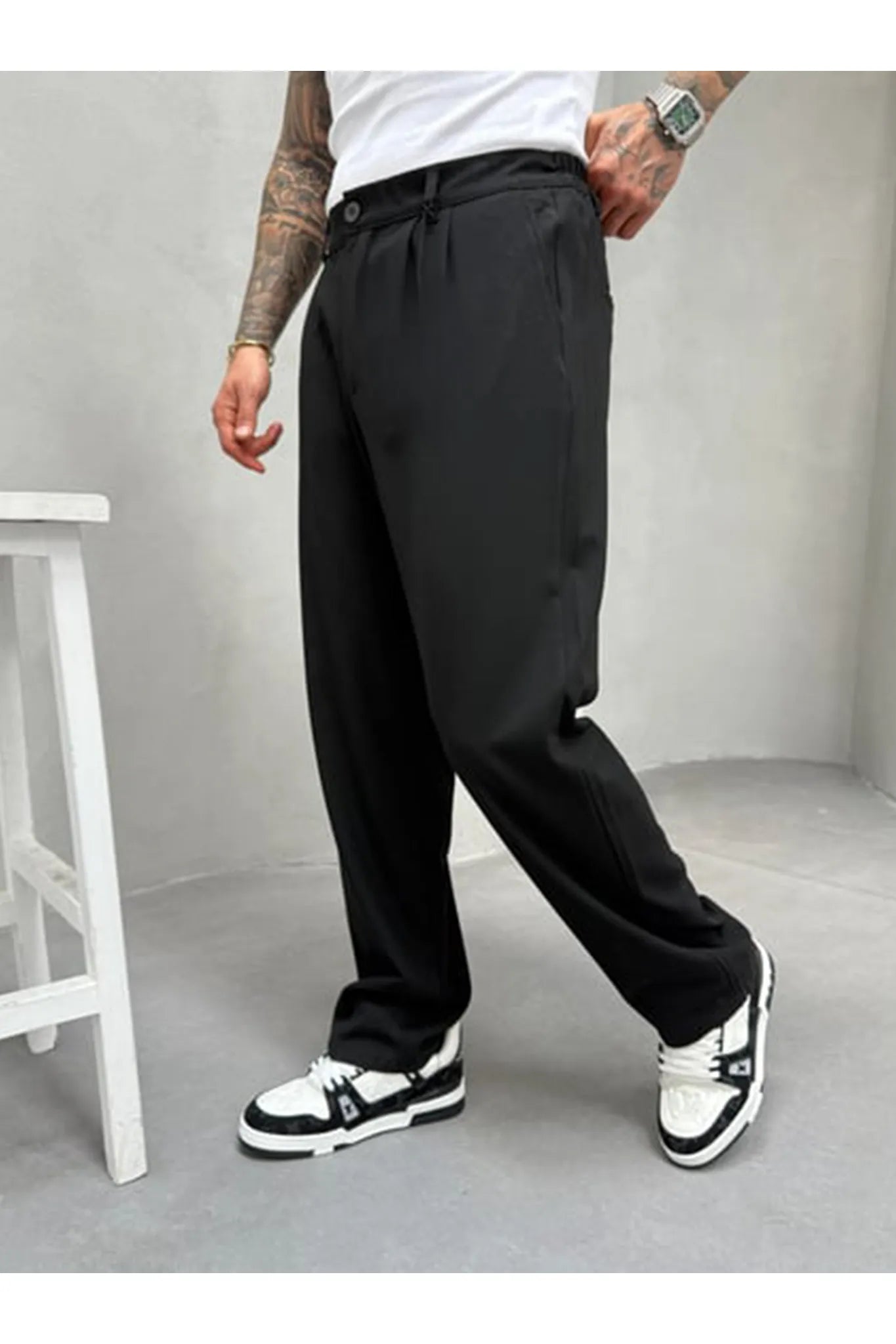 Person wearing black pleated office pants 