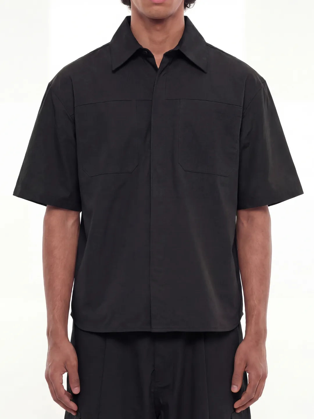 Person wearing a black short-sleeve shirt on a white background