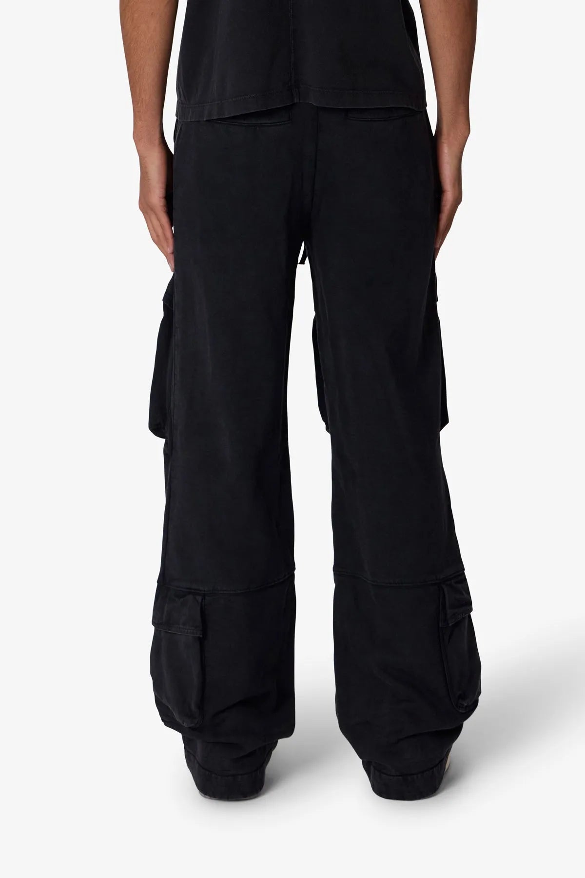 Black cargo pants worn by a person on a white background