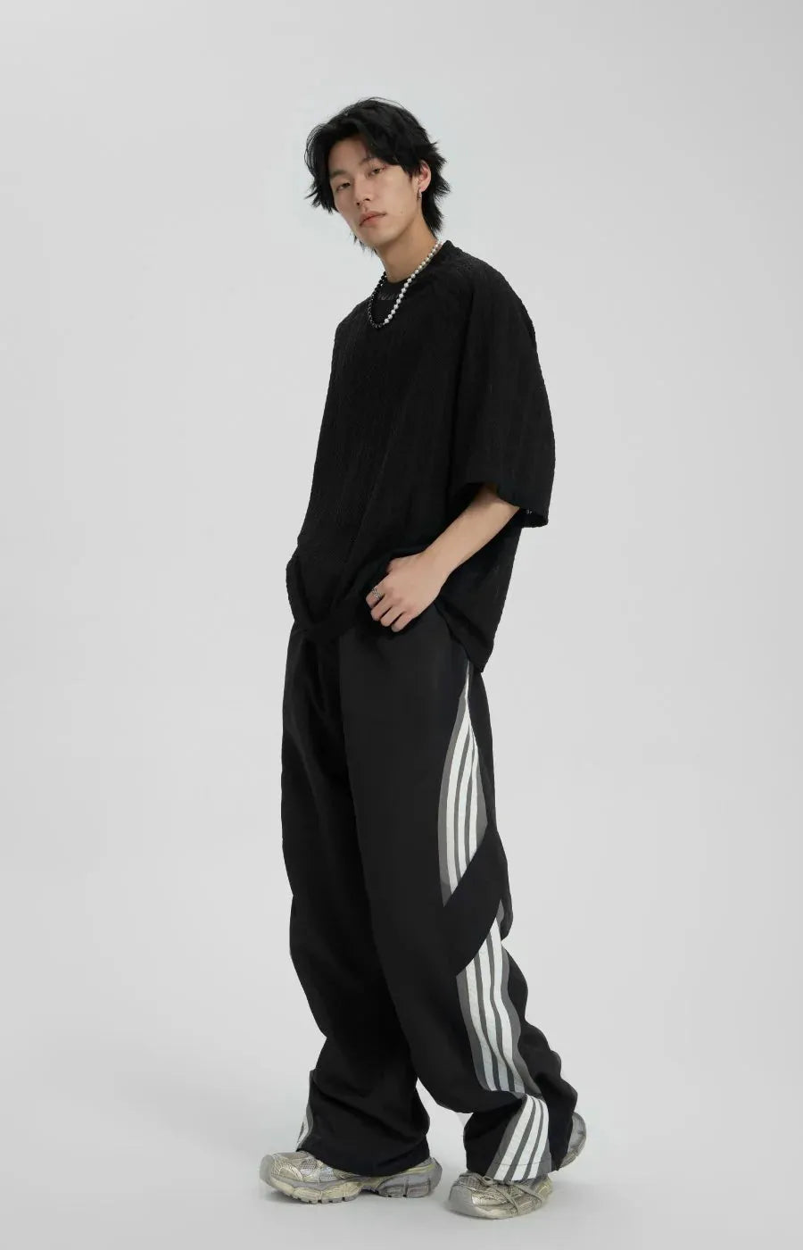 Person wearing a black outfit with white stripes on a white background