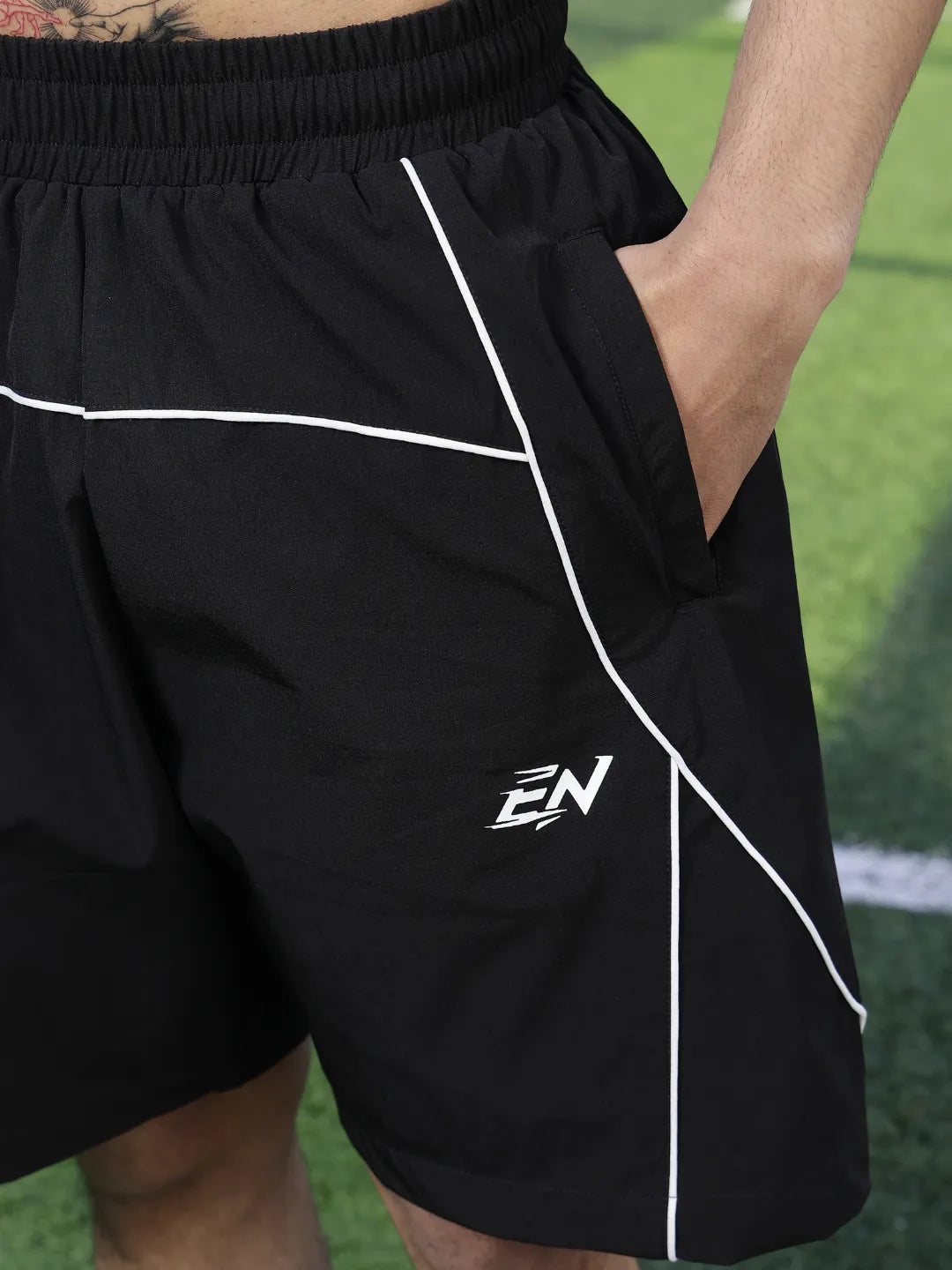 Black shorts with a logo on a grassy field