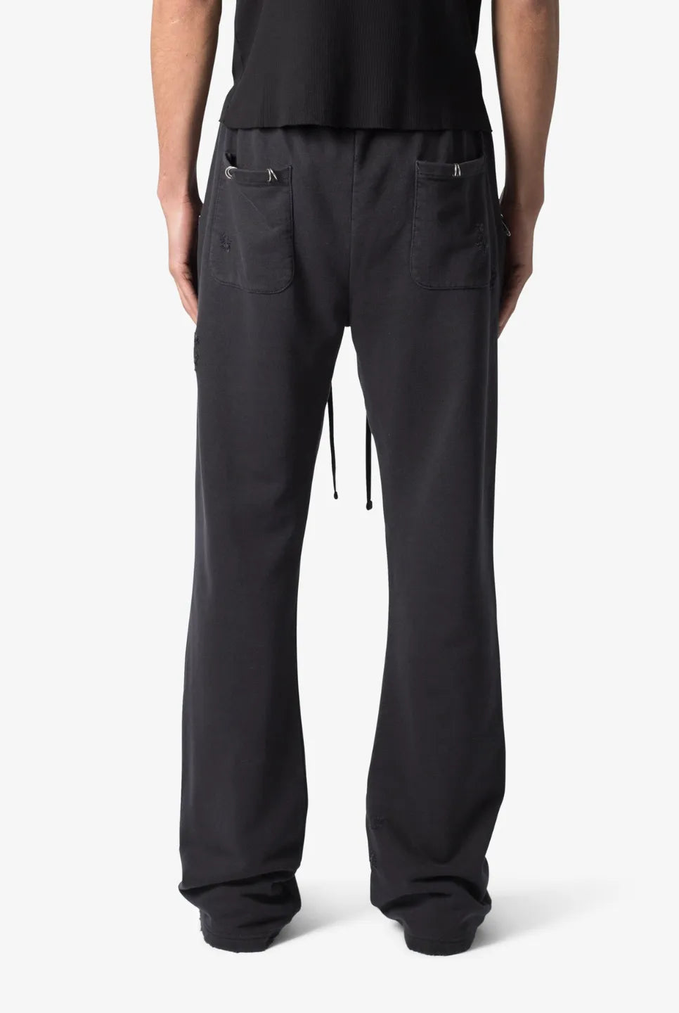 Black sweatpants worn by a person on a white background