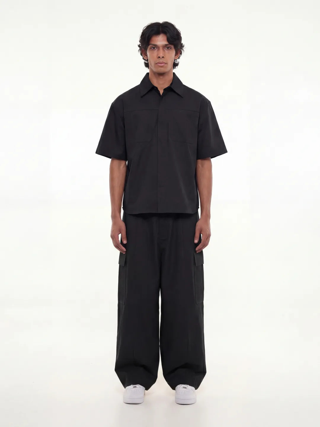 Person wearing a black outfit on a white background
