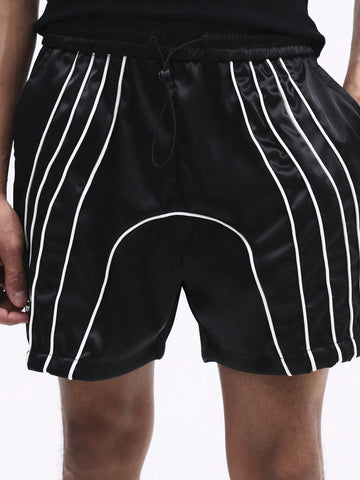 Black shorts with white stripes worn by a person on a plain background