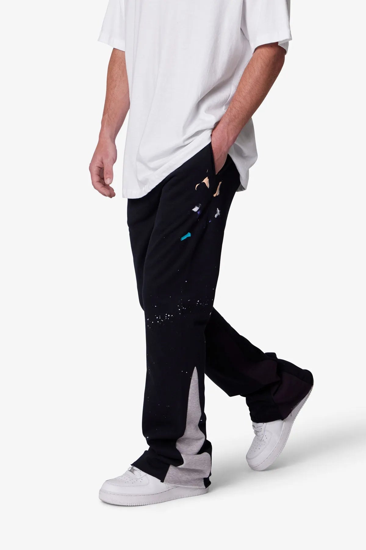 Person wearing black sweatpants with white accents on a white background