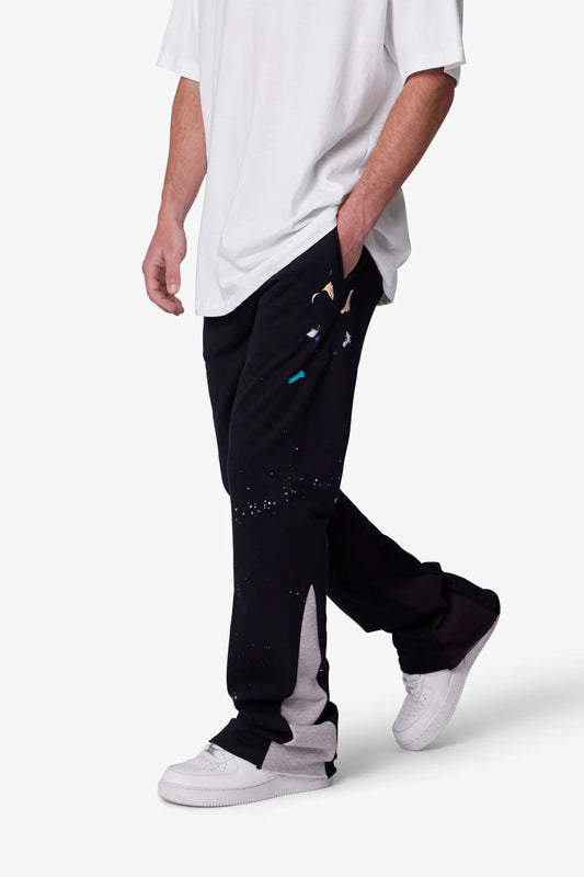 Person wearing black sweatpants with white accents on a white background