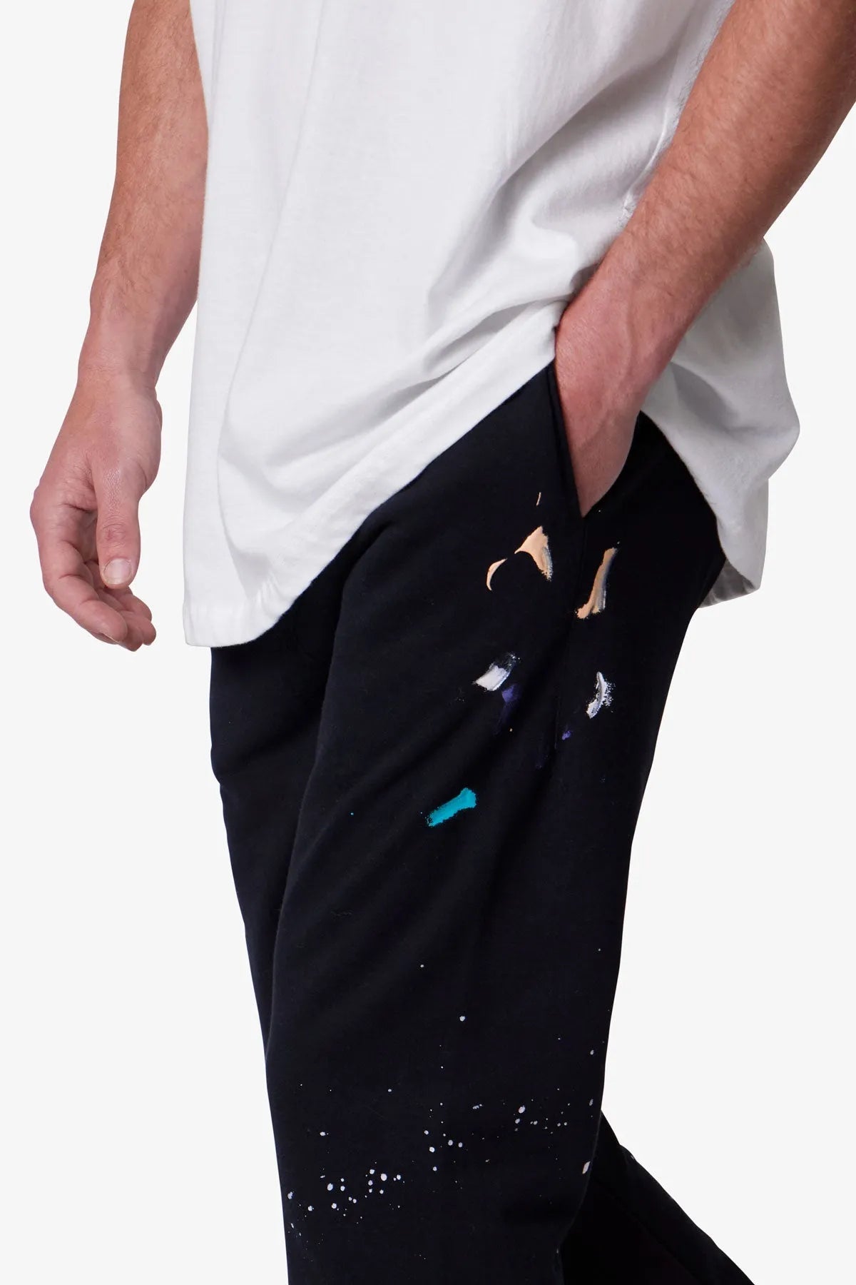 Person wearing black pants with colorful designs on a white background