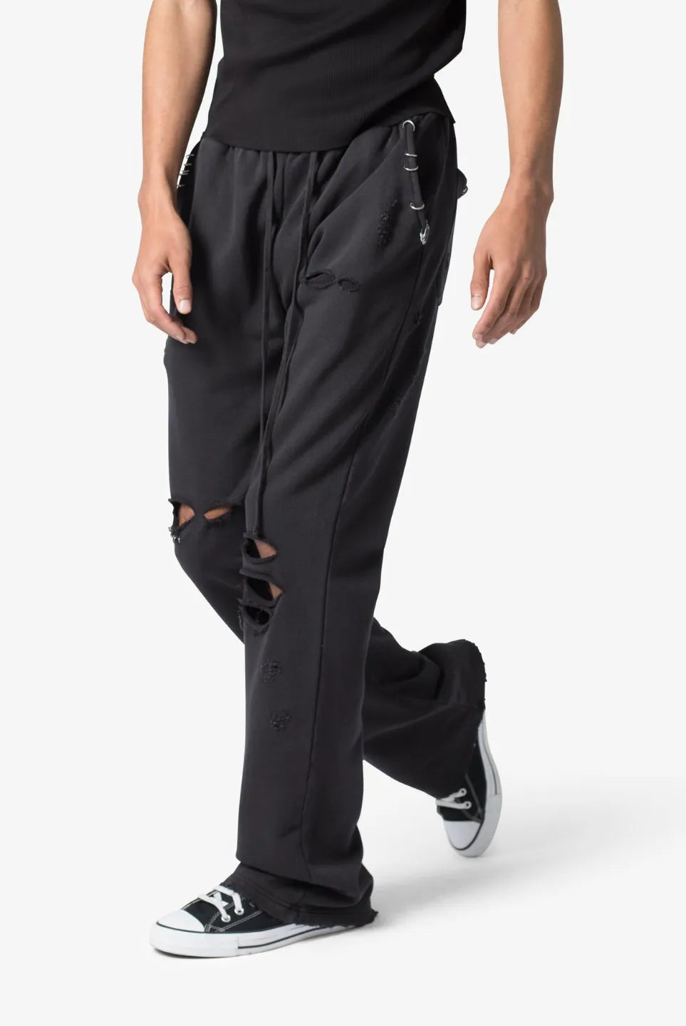 Person wearing black sweatpants with distressed design on a white background