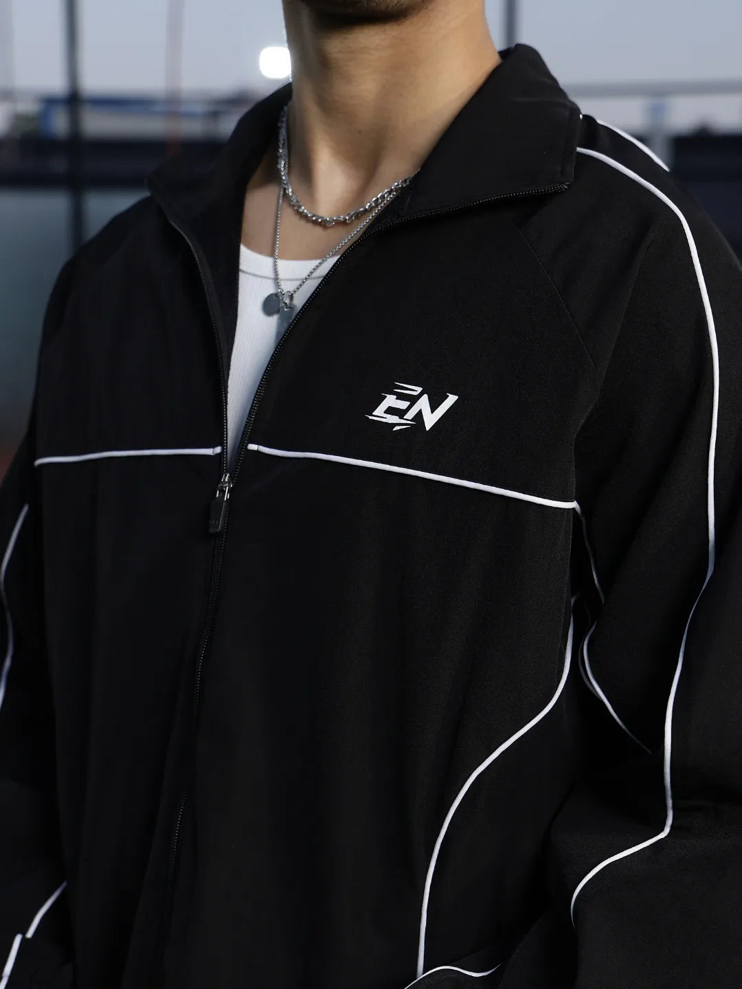 Person wearing a black jacket with a logo on a blurred background