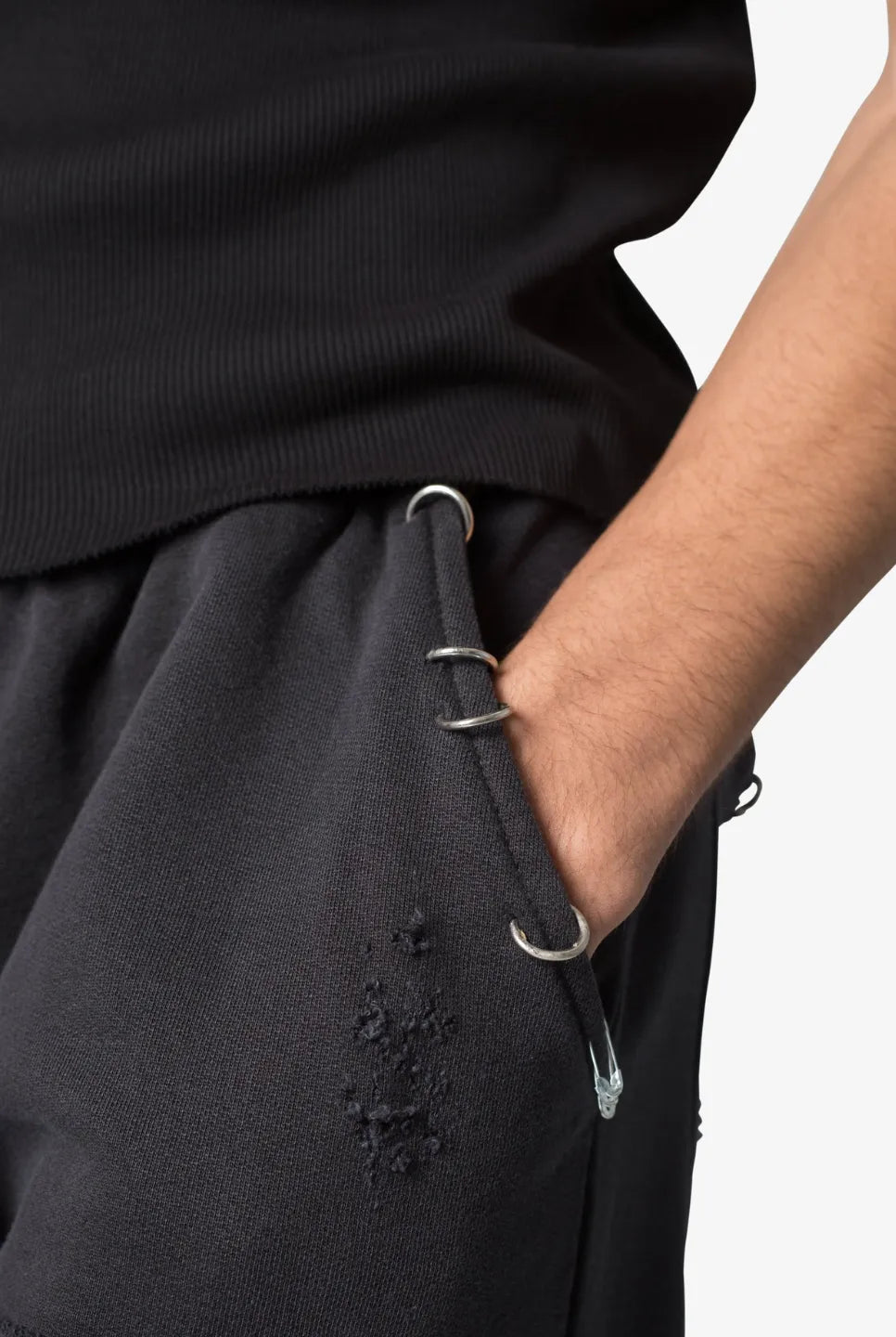 Close-up of a person wearing black sweatpants with a drawstring and a pocket on a white background