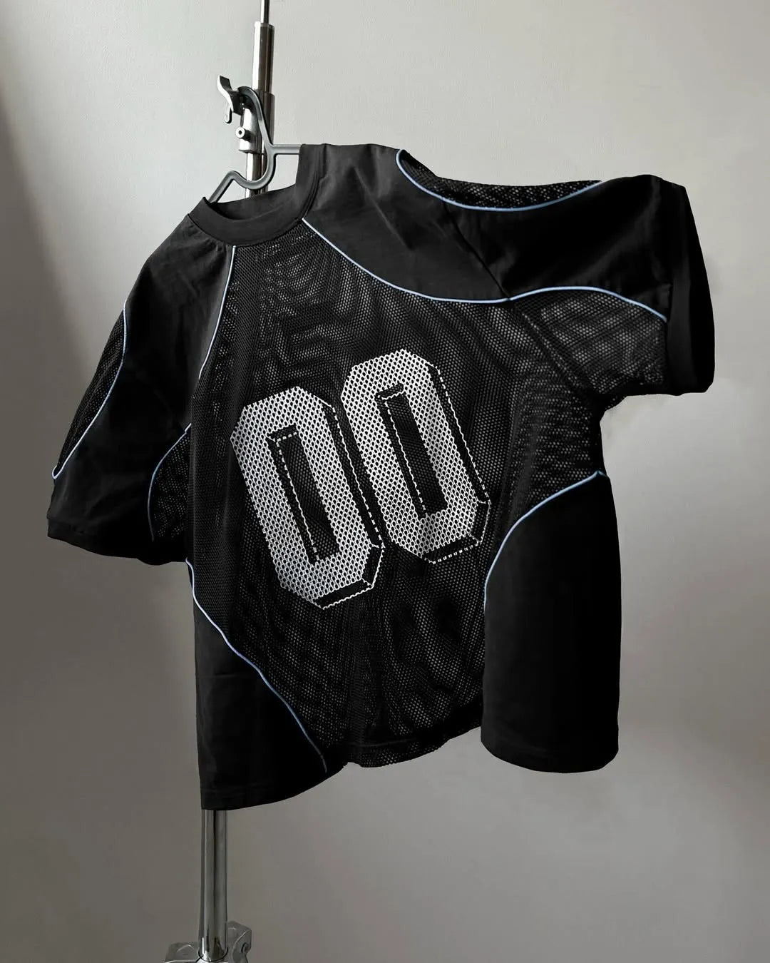 Black sports jersey with number 00 on a stand against a plain background