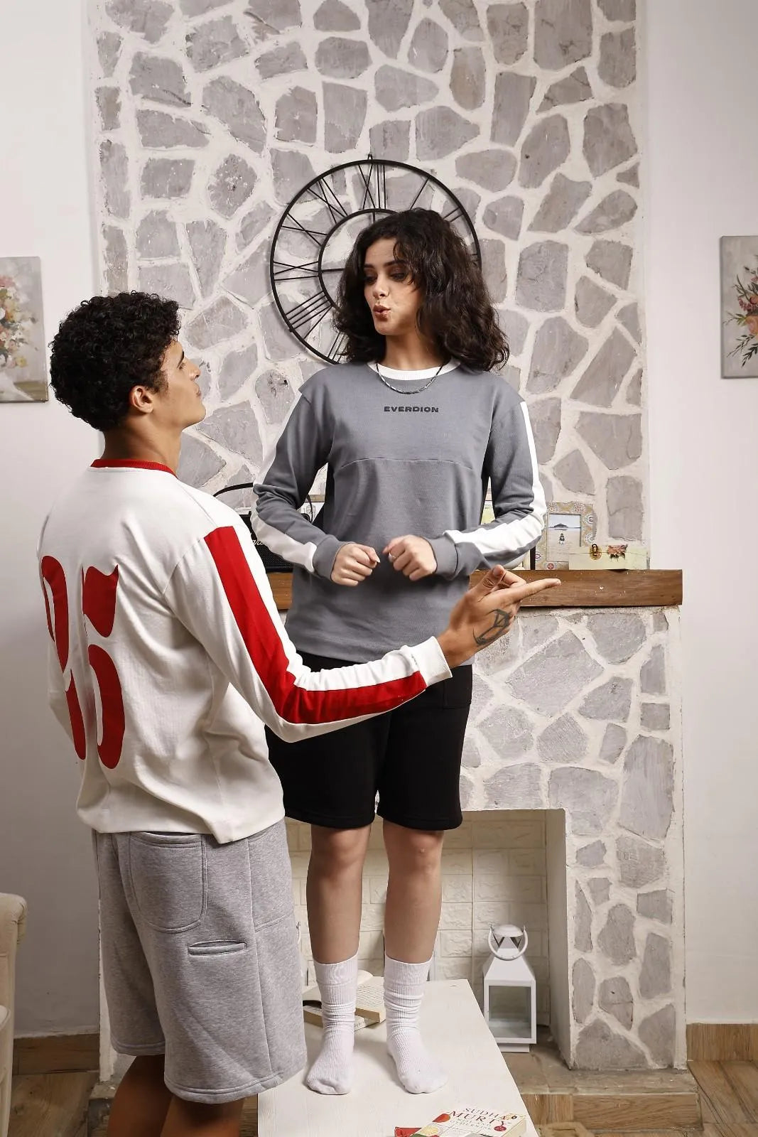 Two people wearing black and grey sweat shorts 