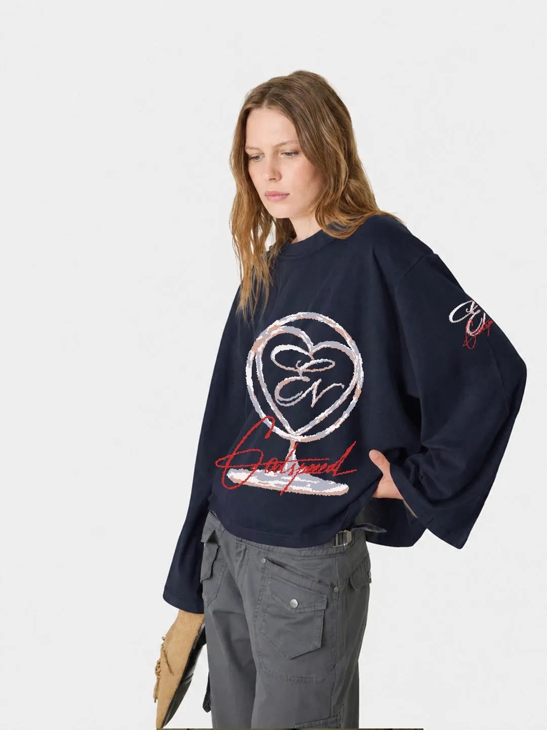 Person wearing a navy blue long sleeve oversized t-shirt with a logo and text on a white background