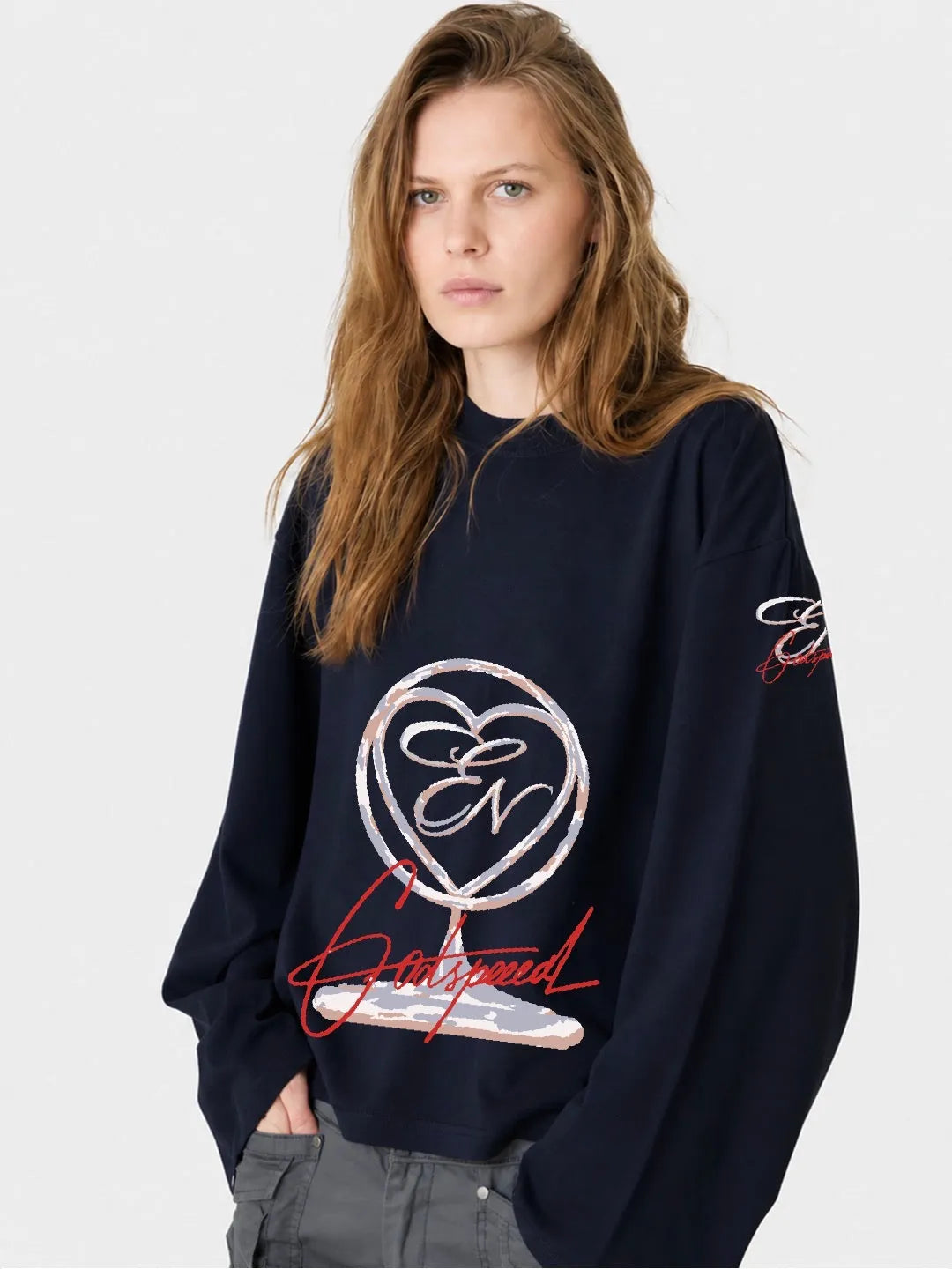 Person wearing a navy blue long sleeve oversized t-shirt with a logo and text on a white background