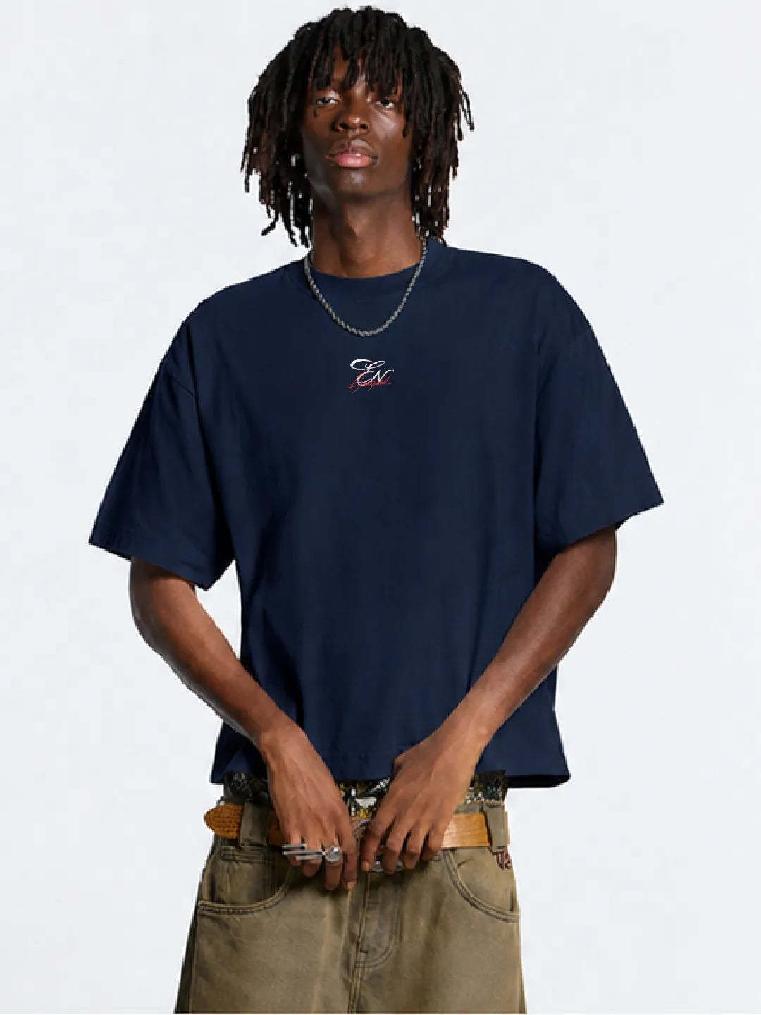 Person wearing a navy blue oversized t-shirt with a logo on a white background