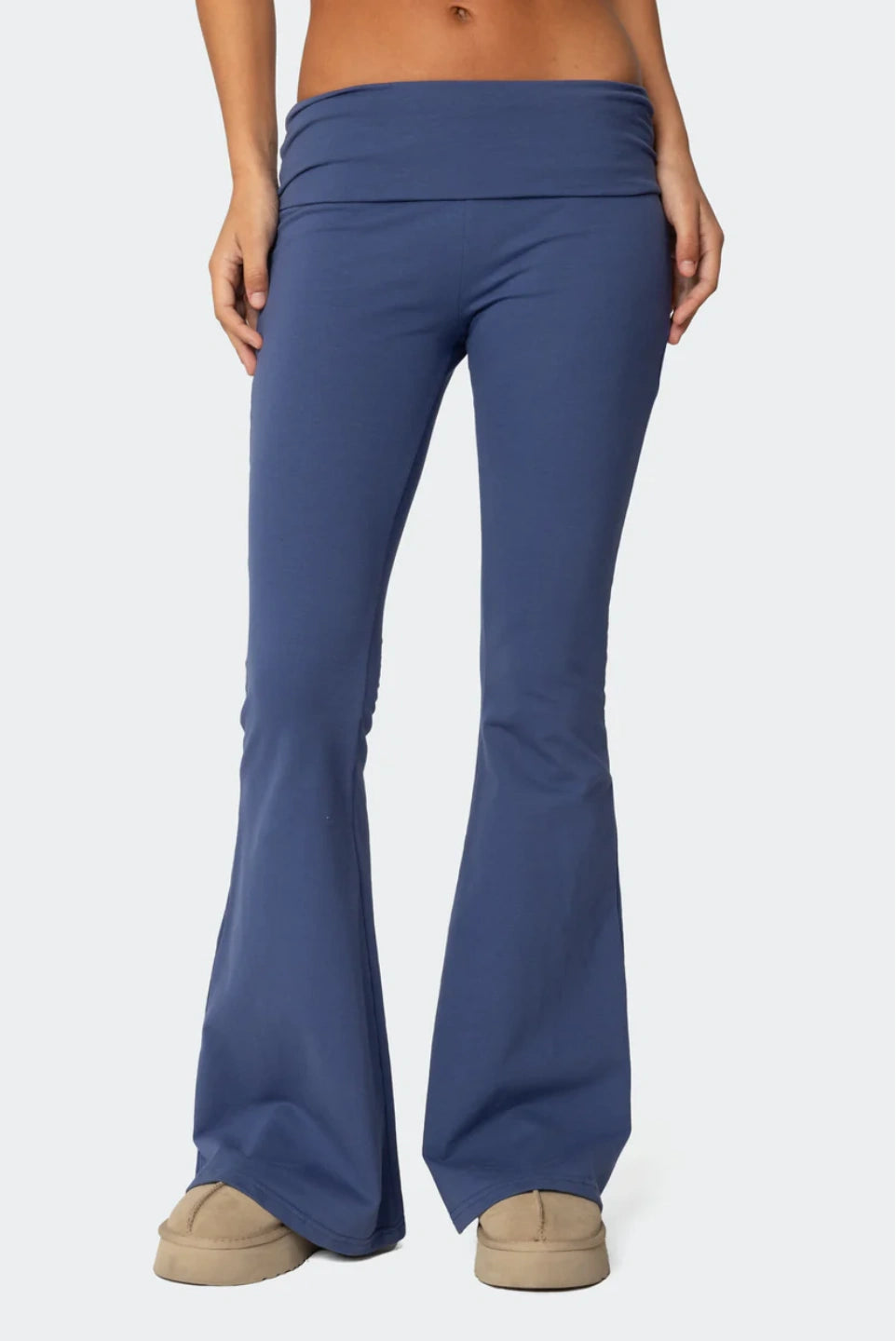 Blue flared pants worn by a person on a white background