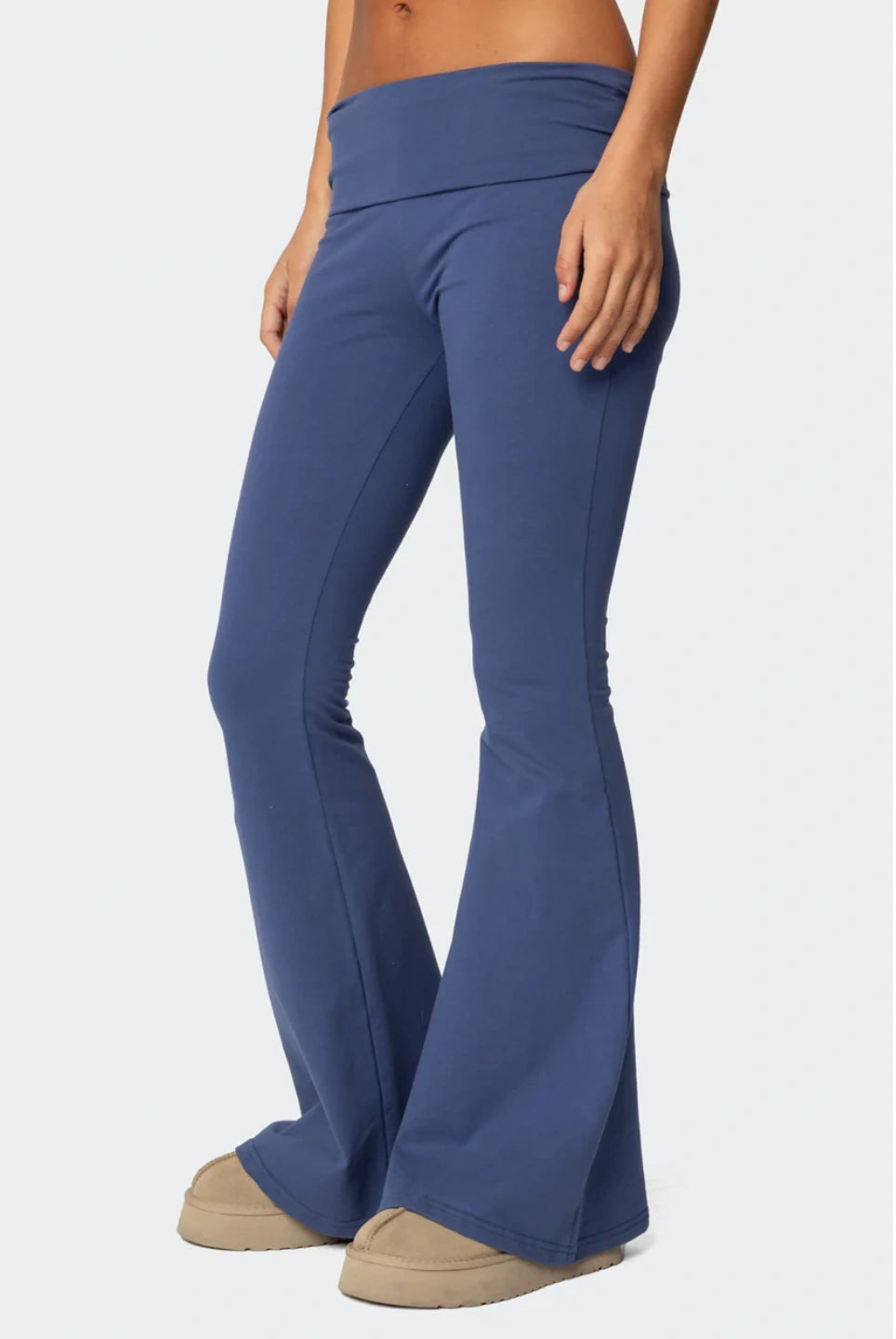 Blue flared pants worn by a person on a white background