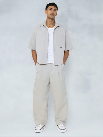 Man wearing a beige shirt and pants with a white background