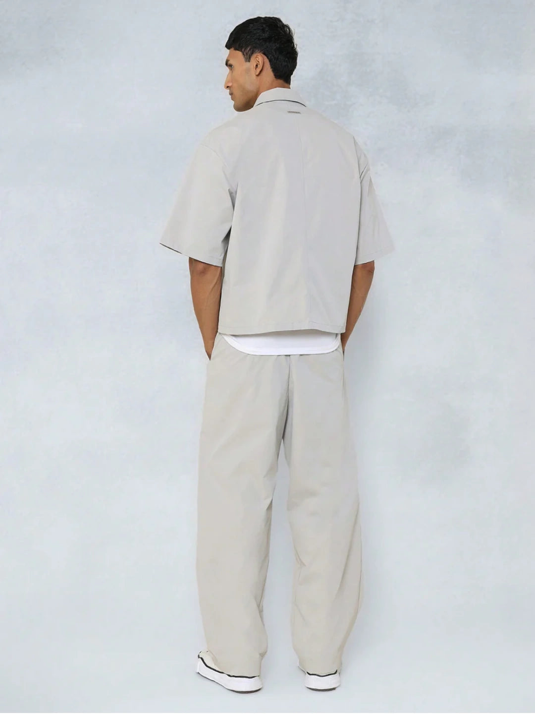 Man wearing a beige outfit against a white background