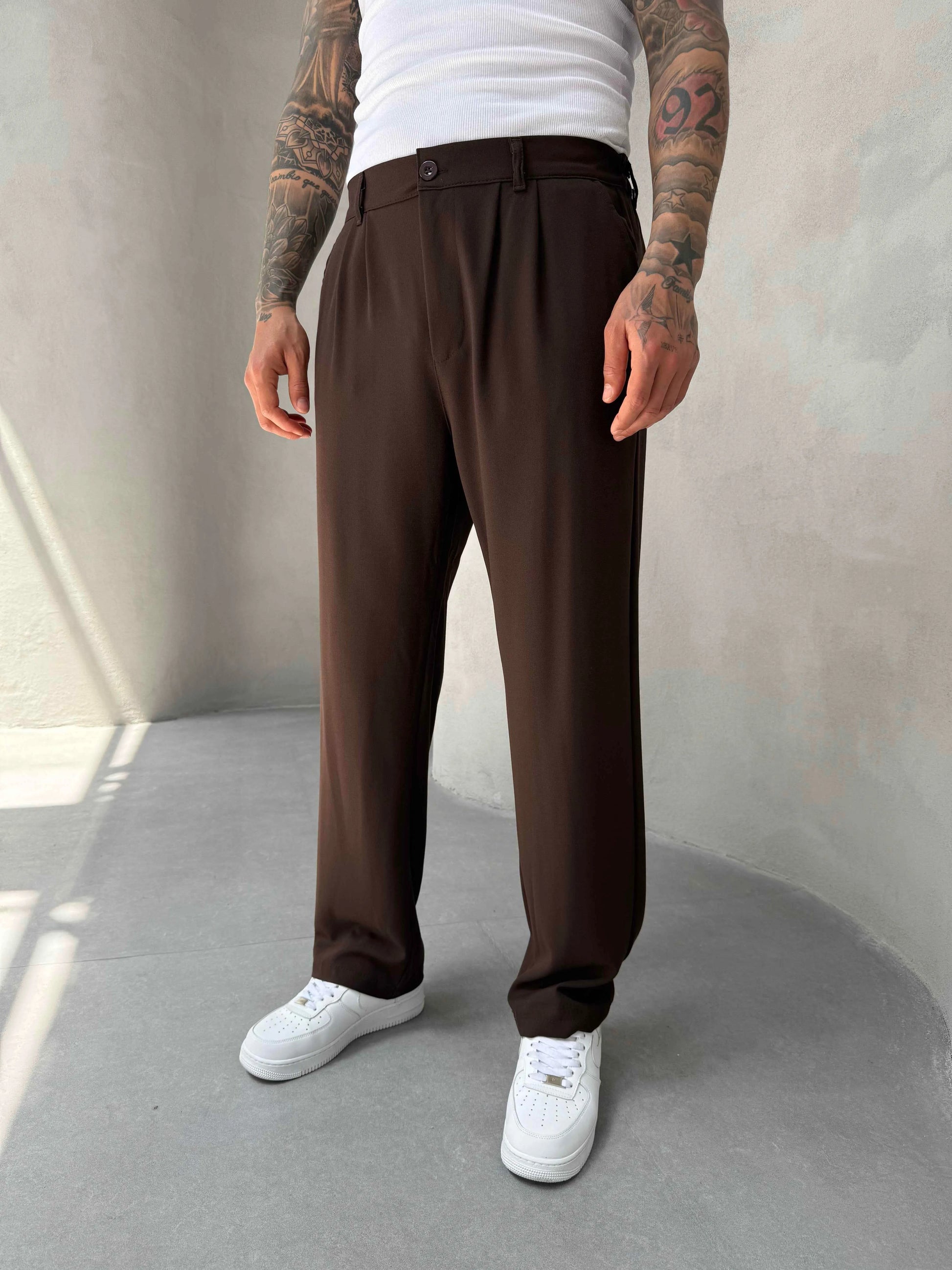 Person wearing brown pleated office pants 