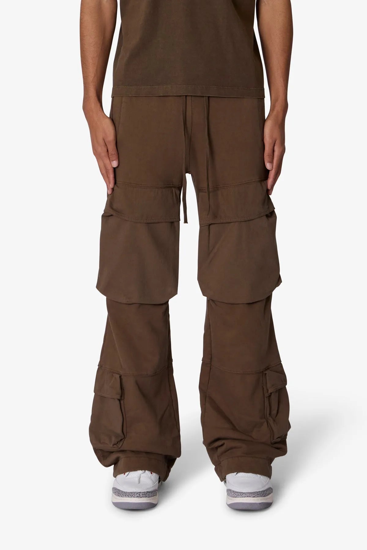 Brown cargo pants worn by a person on a white background