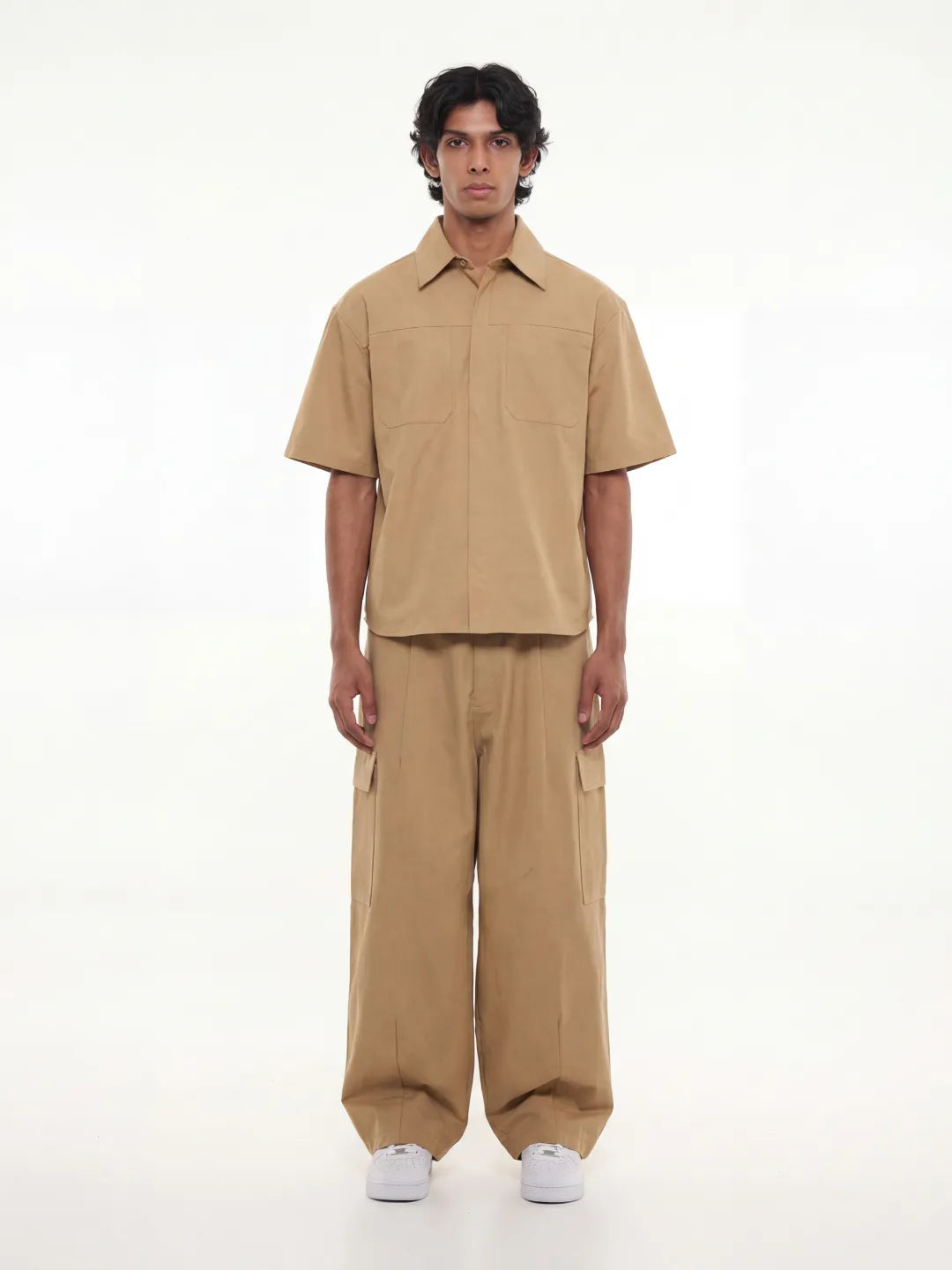 Man wearing a beige outfit on a white background