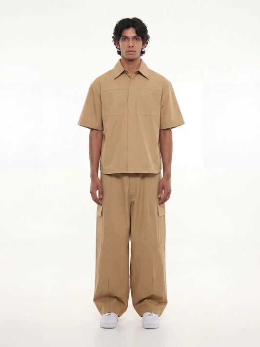Man wearing a beige outfit on a white background