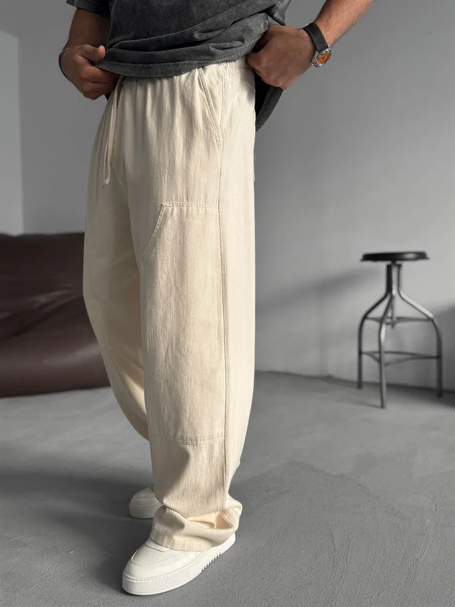 Person wearing beige linen pants with a neutral background