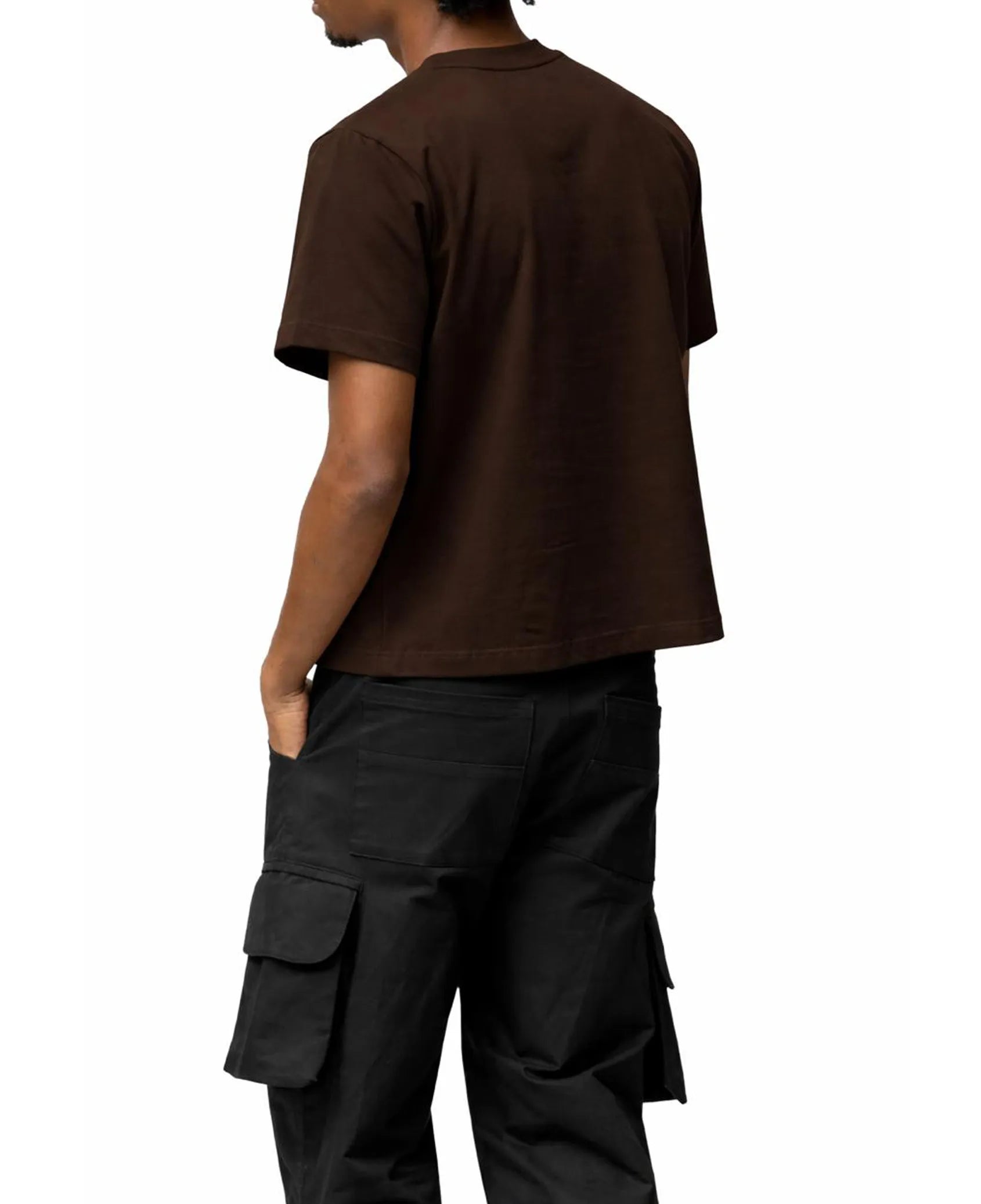 Person wearing a brown t-shirt and black cargo pants on a white background