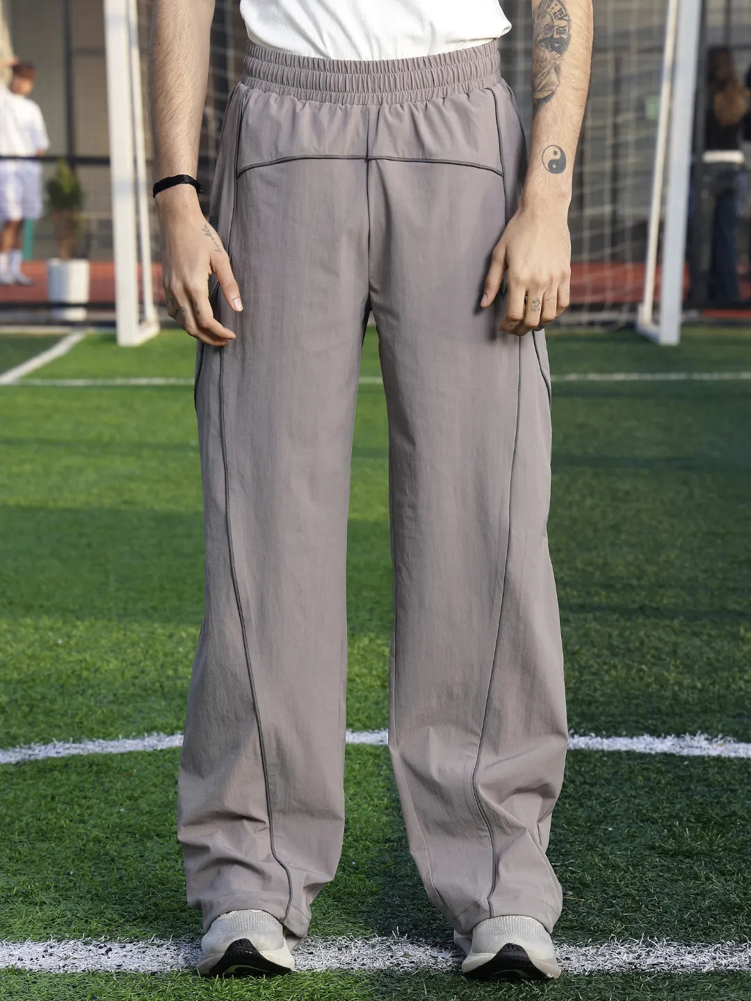 Person wearing grey sweatpants on a sports field