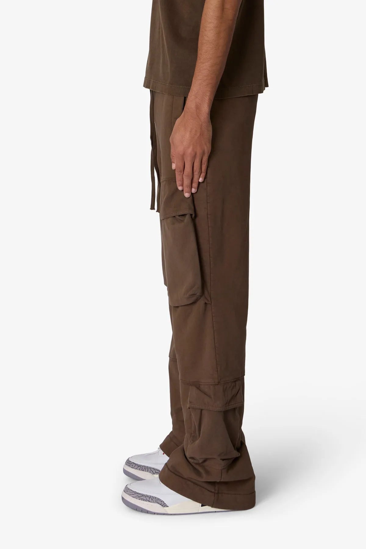 Brown cargo pants worn by a person on a white background