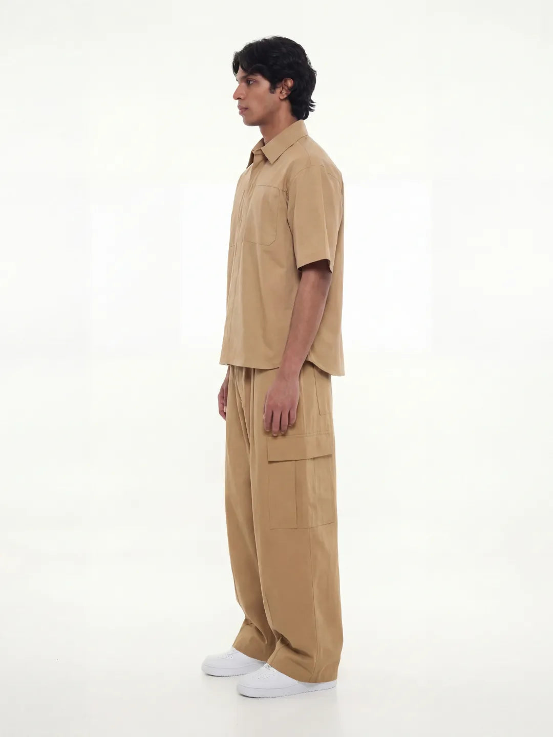 Man wearing a beige outfit on a white background