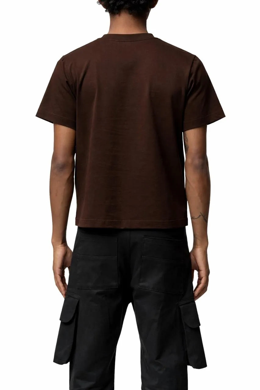 Person wearing a brown t-shirt and black cargo pants on a white background