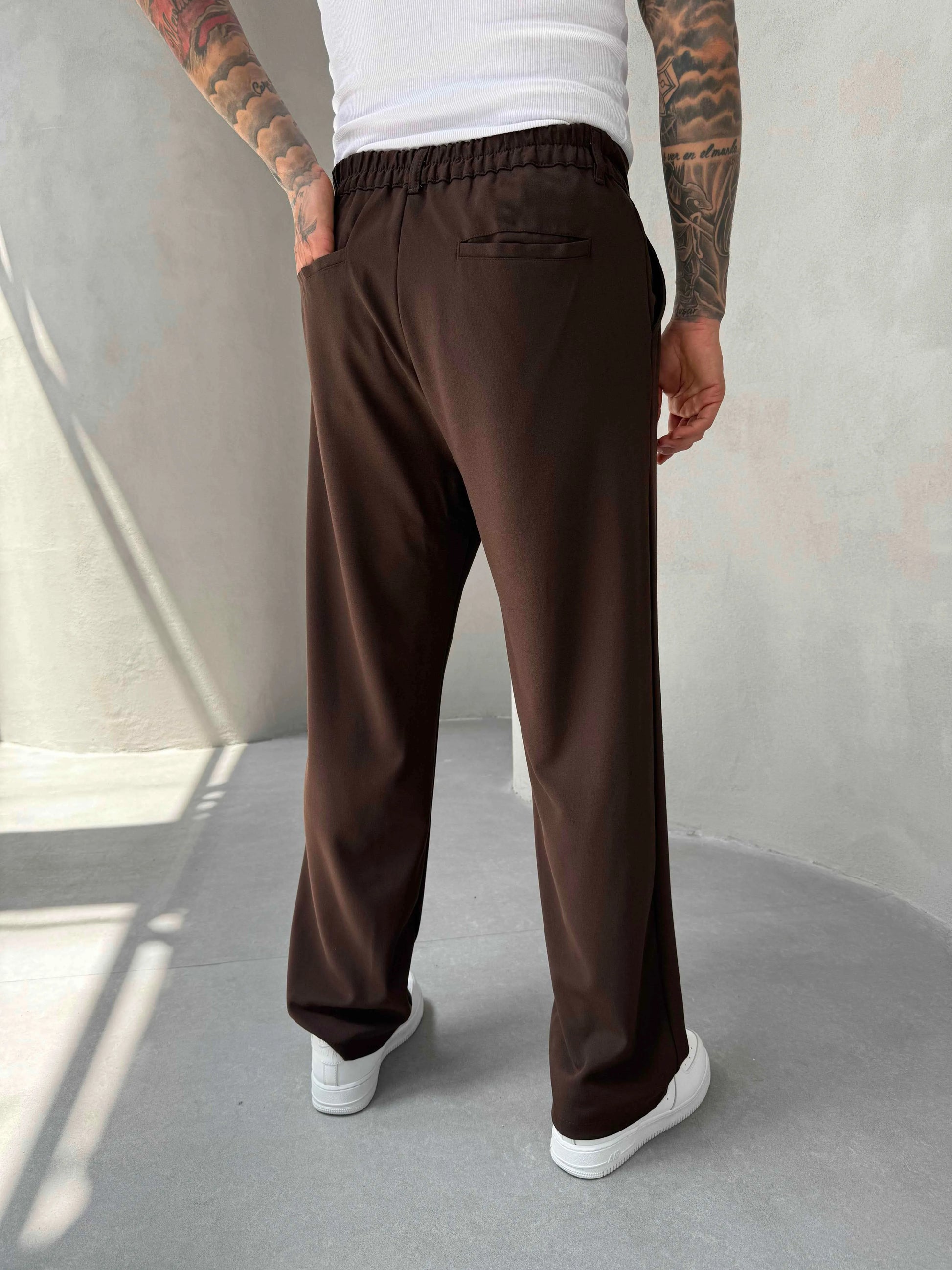 Person wearing brown pleated office pants 