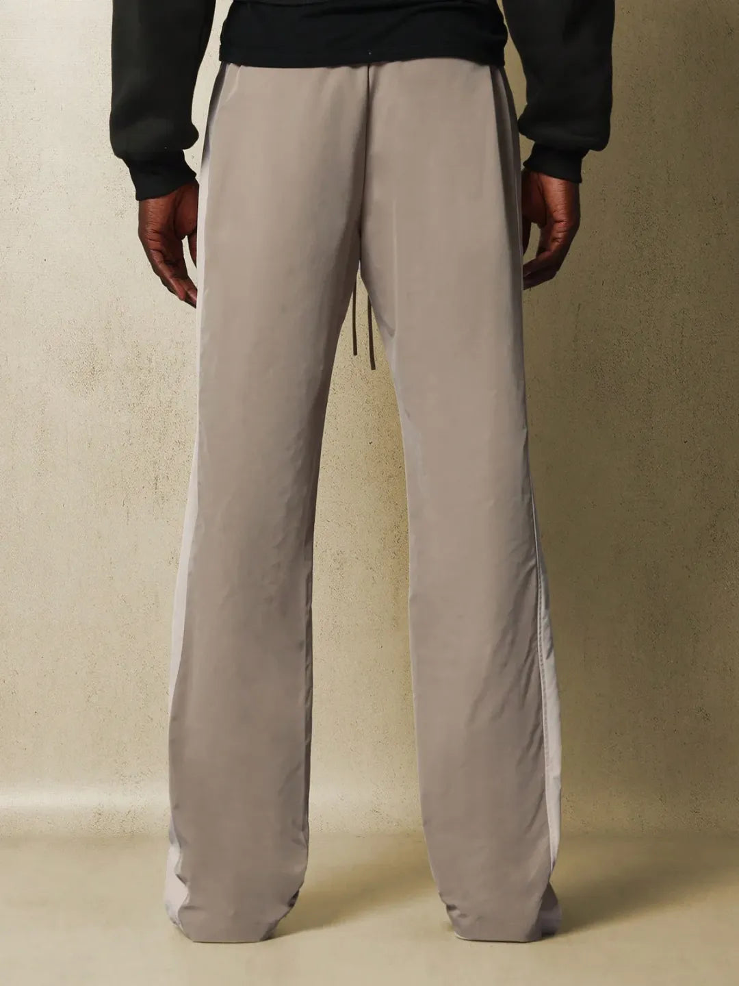 Person wearing grey pants with a plain background