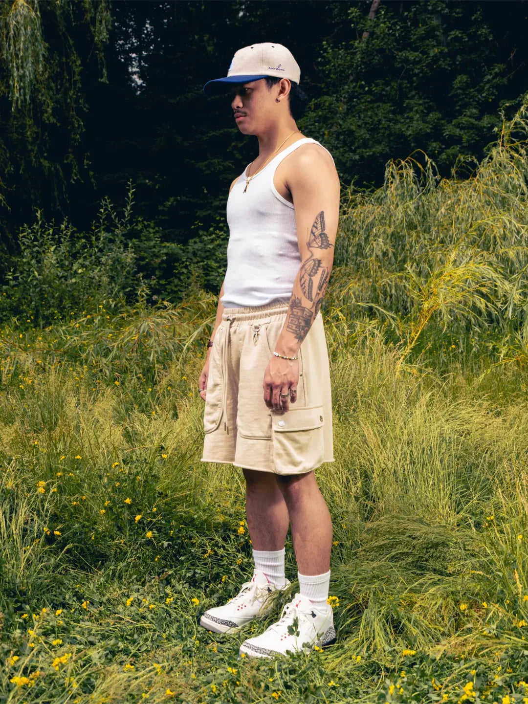 Beige shorts worn by a person in a natural setting with greenery.