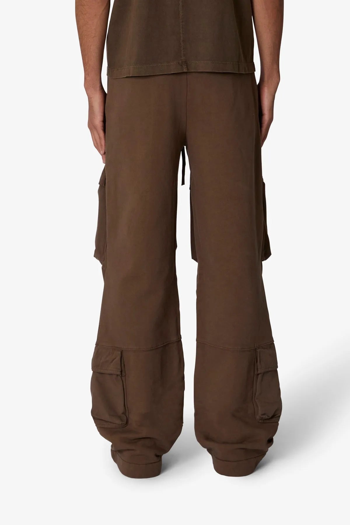 Brown cargo pants worn by a person on a white background