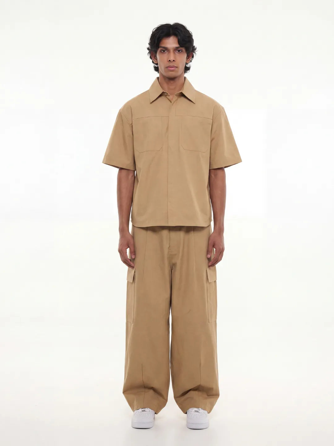 Man wearing a beige outfit on a white background