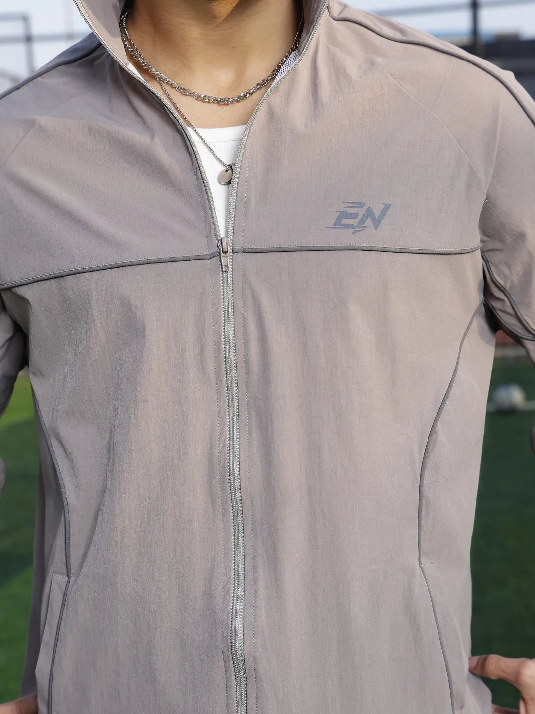 Grey jacket with a brand logo on a blurred outdoor background