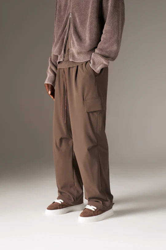 Kyoto Brown Cargo Pant is a modern utility essential designed with a relaxed wide-leg silhouette for effortless everyday wear. Crafted with a technical, structured fabric, these cargo pants balance durability with comfort, making them ideal for contemporary streetwear and elevated casual styling.