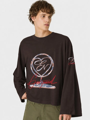Person wearing a black long-sleeve oversized t-shirt with a logo and text on a white background